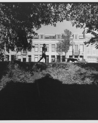 Analogue film photography of a morning scene in Amsterdam featuring a person walking a dog, by Jeroen Busschers