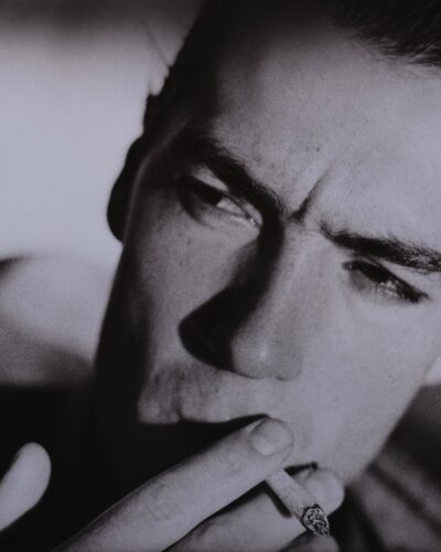 Analogue film photography portrait of a young man smoking a cigarette, dramatic shadow composition, cinamatic black and white studio portraiture, by Jeroen Busschers