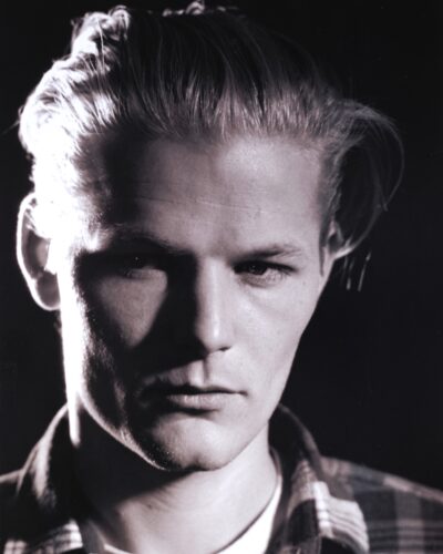 Analogue film photography portrait of a young man, high contrast chairoscuro studio lighting, dramatic black and white fine art portaiture, by Jeroen Busschers