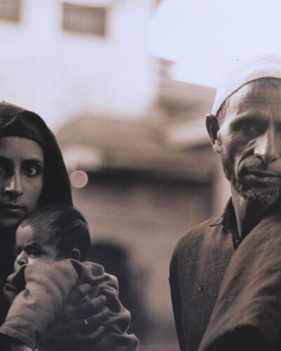 Analogue film photography, portrait of a Kashmiri family with a baby, powerfull black and white travel documentary photography in Kashmir, India, by Jeroen Busschers