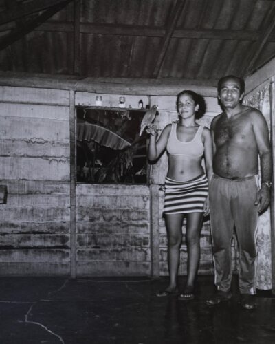 Analogue film photography of a Cuban father and daughter with parrot inside their rural home near Baracoa, Cuban Interiors series by Jeroen Busschers