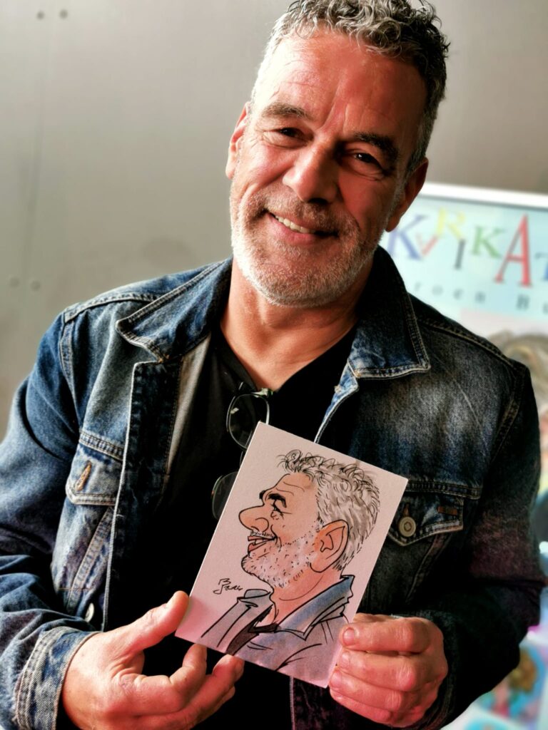 Een glimlachende persoon toont zijn handgetekende karikatuur -Professionele karikatuurtekenaar Jeroen Busschers is te boeken door heel Nederland en Belgie.